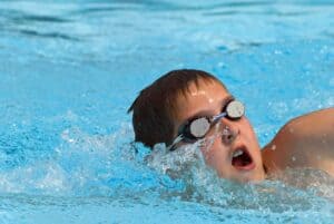 dreng svømmer med svømmebriller